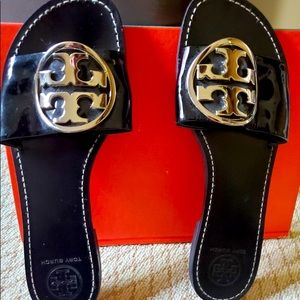 Tory Burch black flat sandals with gold emblem